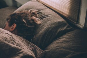 Imagen de una mujer durmiendo bajo las mantas