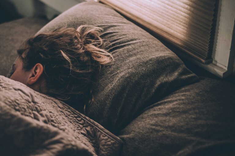 Imagen de una mujer durmiendo bajo las mantas